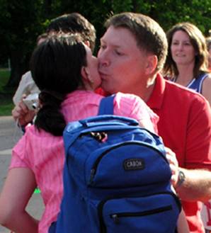 Man kissing a woman's cheek in greeting